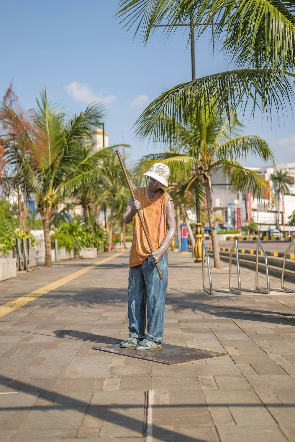 a man standing on a sidewalk with a broom