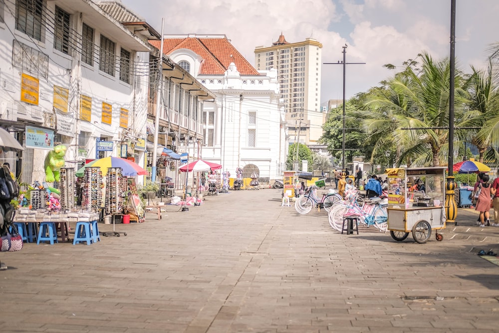 a group of people walking down a street next to tall buildings