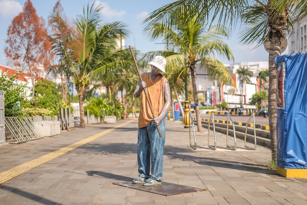 a man standing on a sidewalk with a broom