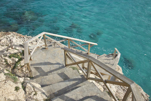a staircase going down to the ocean from a cliff