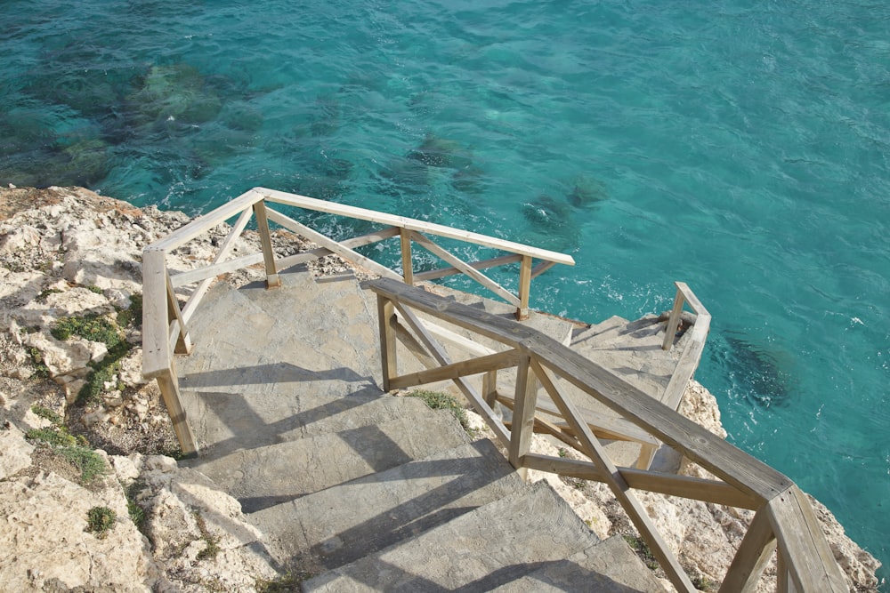 a staircase going down to the ocean from a cliff