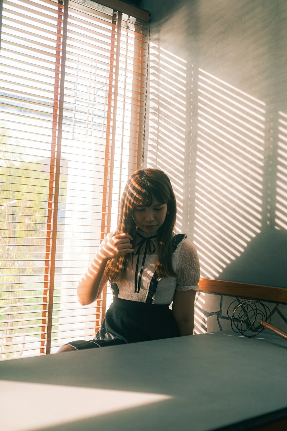 a woman sitting on a bed in front of a window