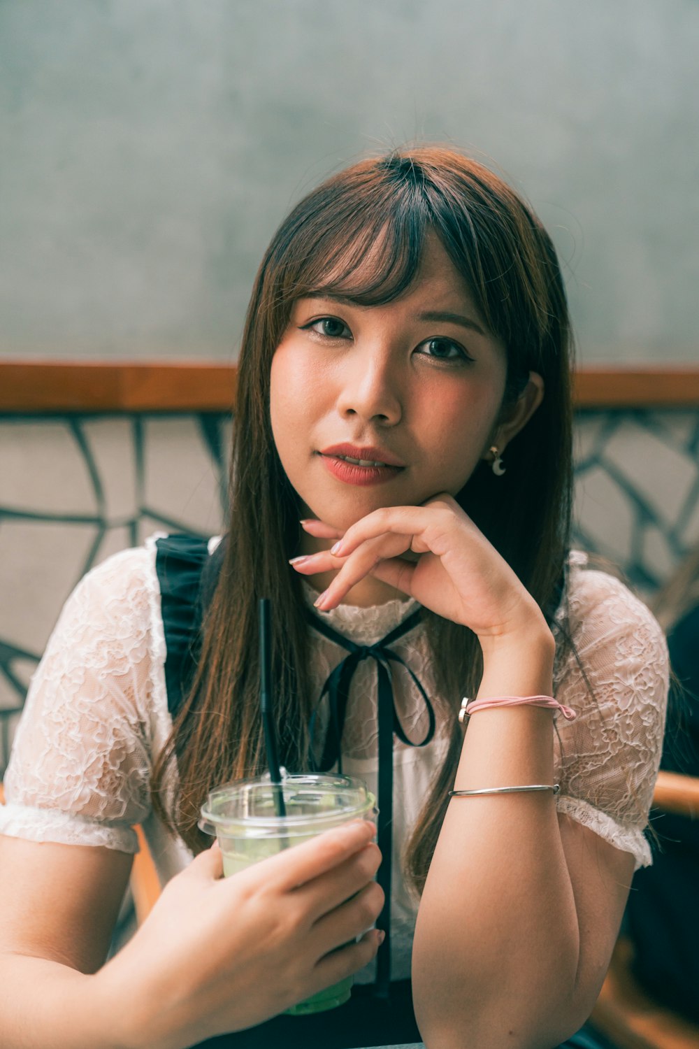 a woman sitting at a table with a drink in her hand