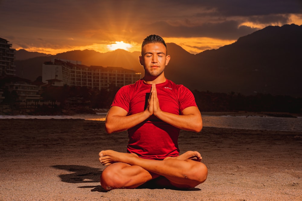 a man in a red shirt is doing yoga