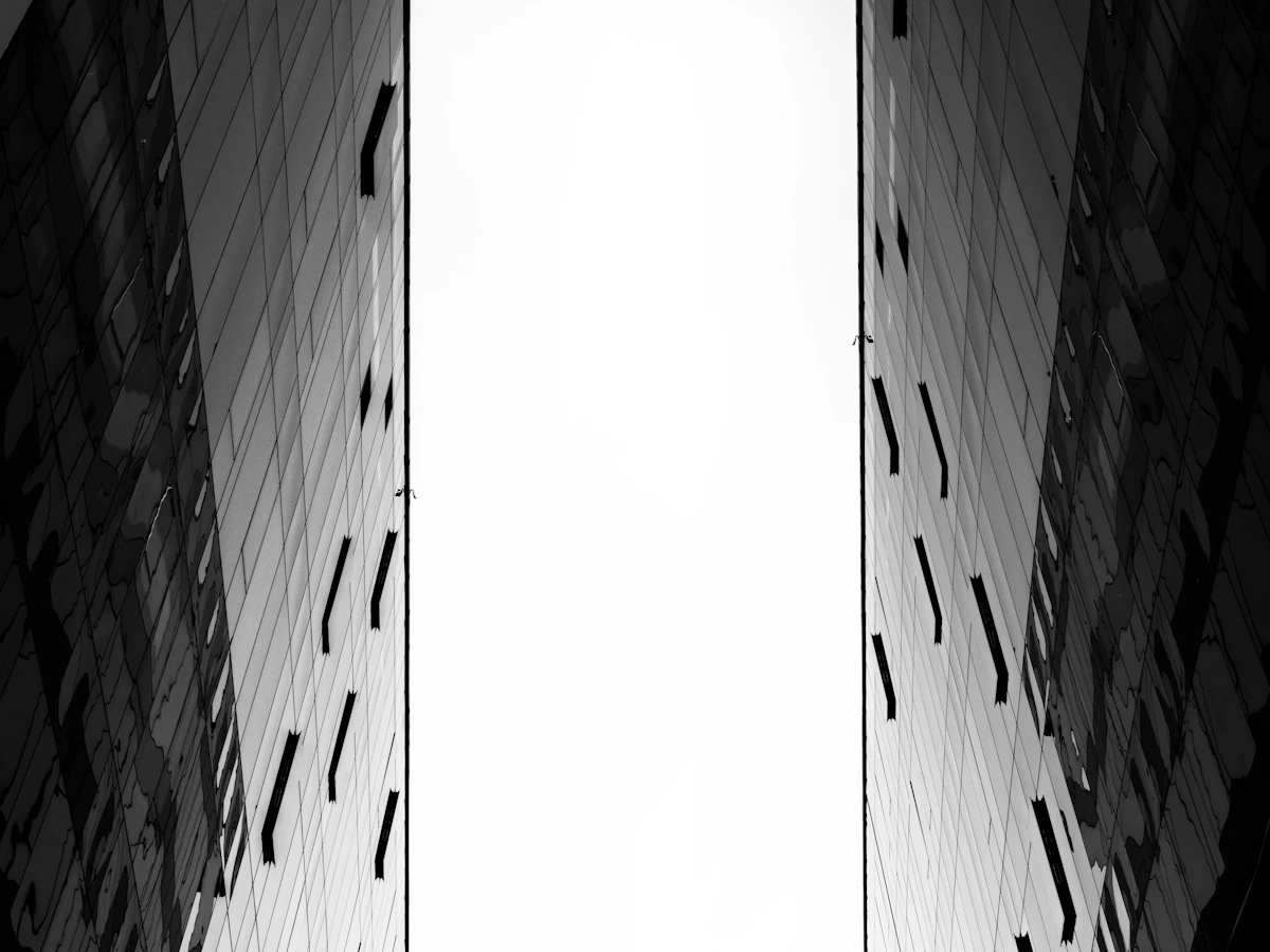 Two tall buildings against a pale sky