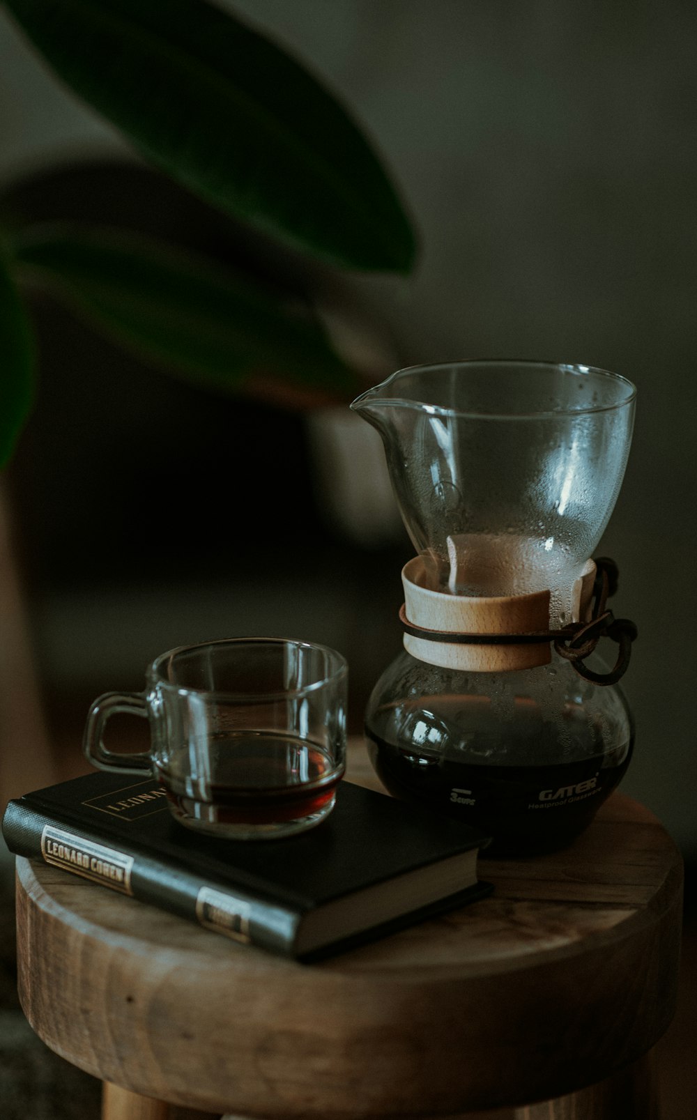 a wooden table topped with a cup of coffee and a book