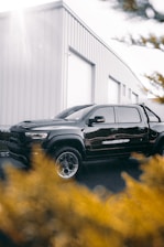 A sleek Isuzu truck parked in front of a modern warehouse under clear skies.
