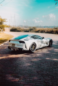 A sleek sports car parked beside a content creator filming a dynamic automotive review outdoors.