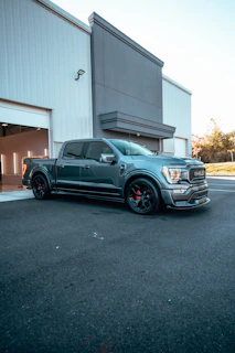 Sleek dark blue trailer attached to a modern pickup truck in an industrial setting
