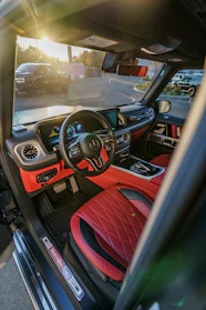 the interior of a car with red and black seats