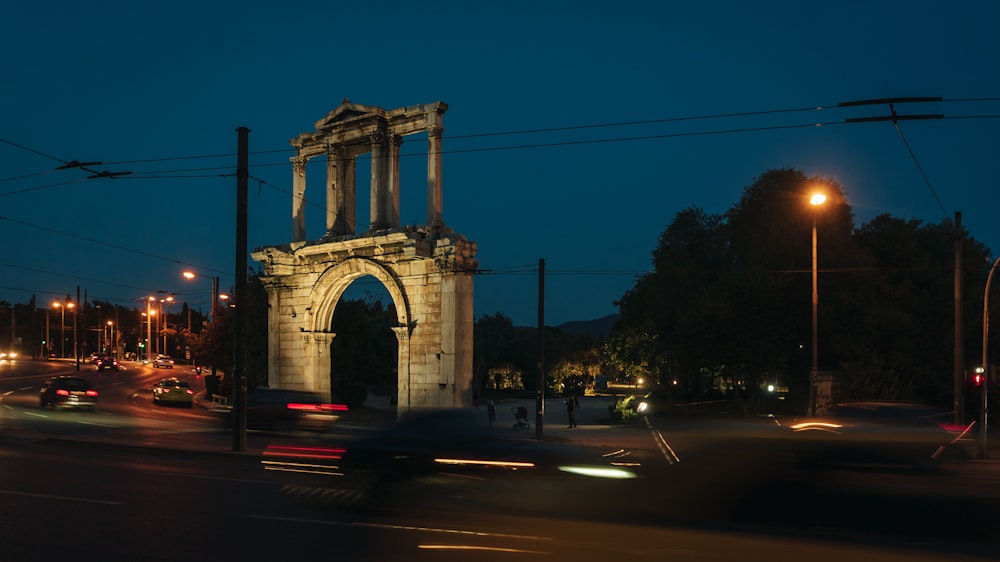 a city street at night with cars passing by