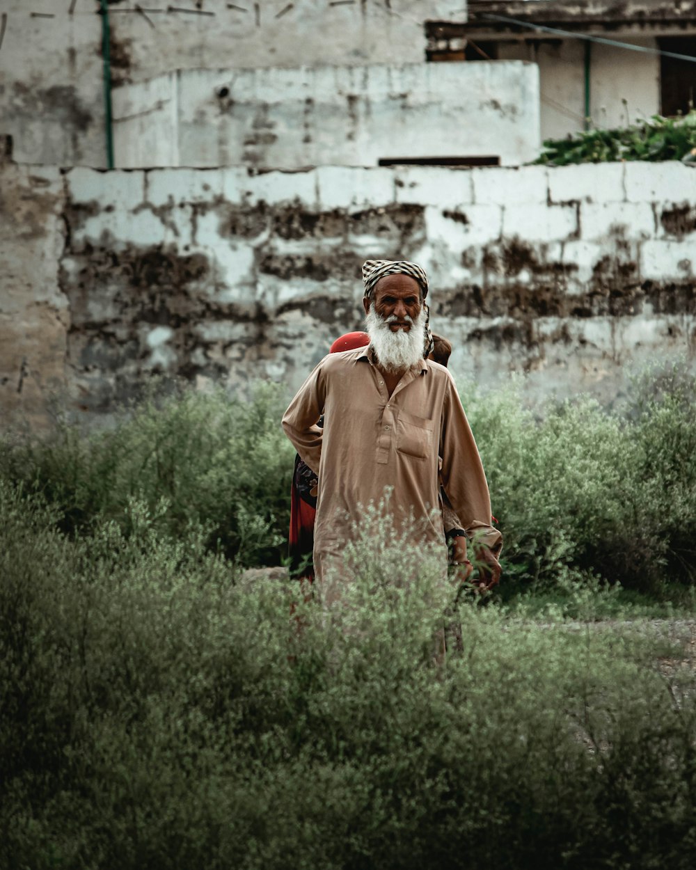 a man with a white beard standing in a field