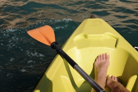 a person sitting in a yellow kayak in the water