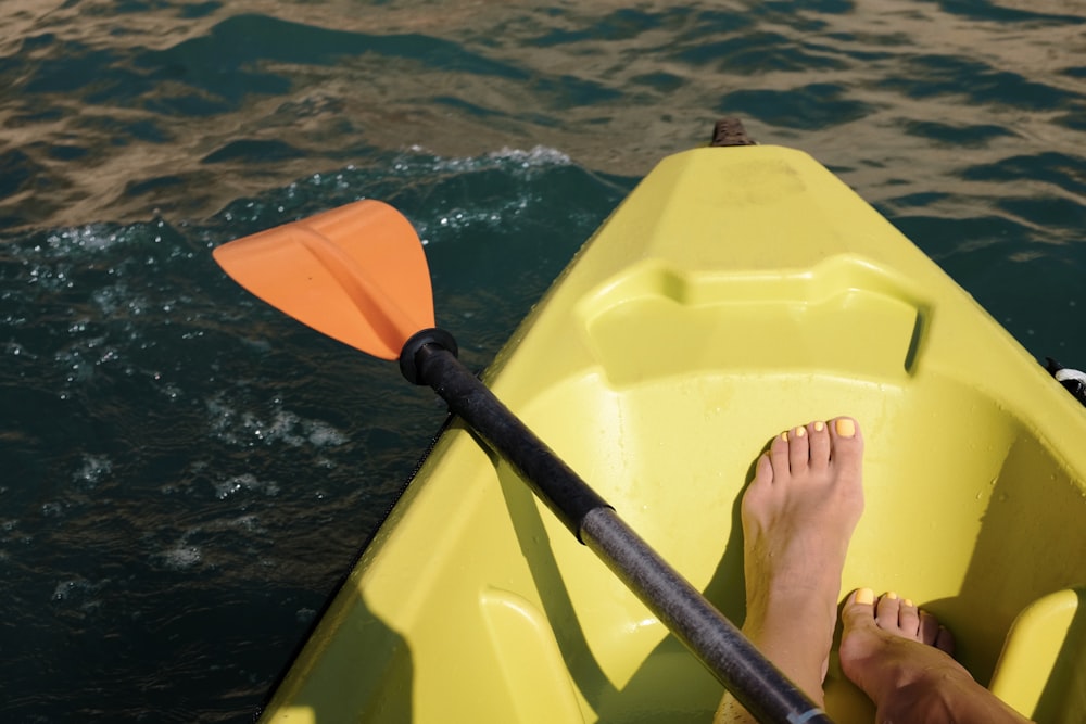 una persona seduta in un kayak giallo nell'acqua