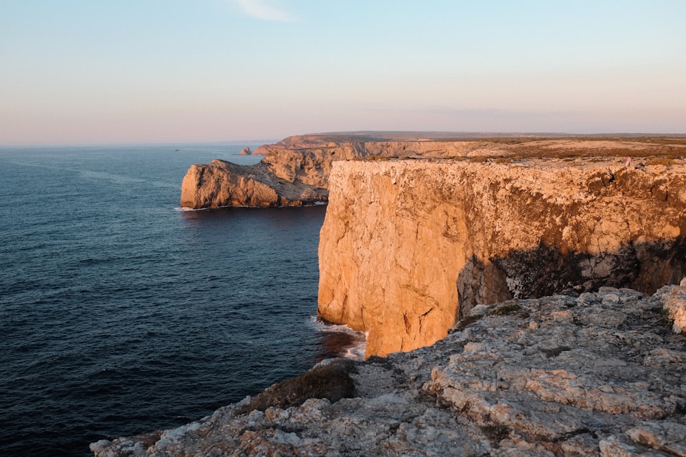 a rocky cliff overlooks a body of water