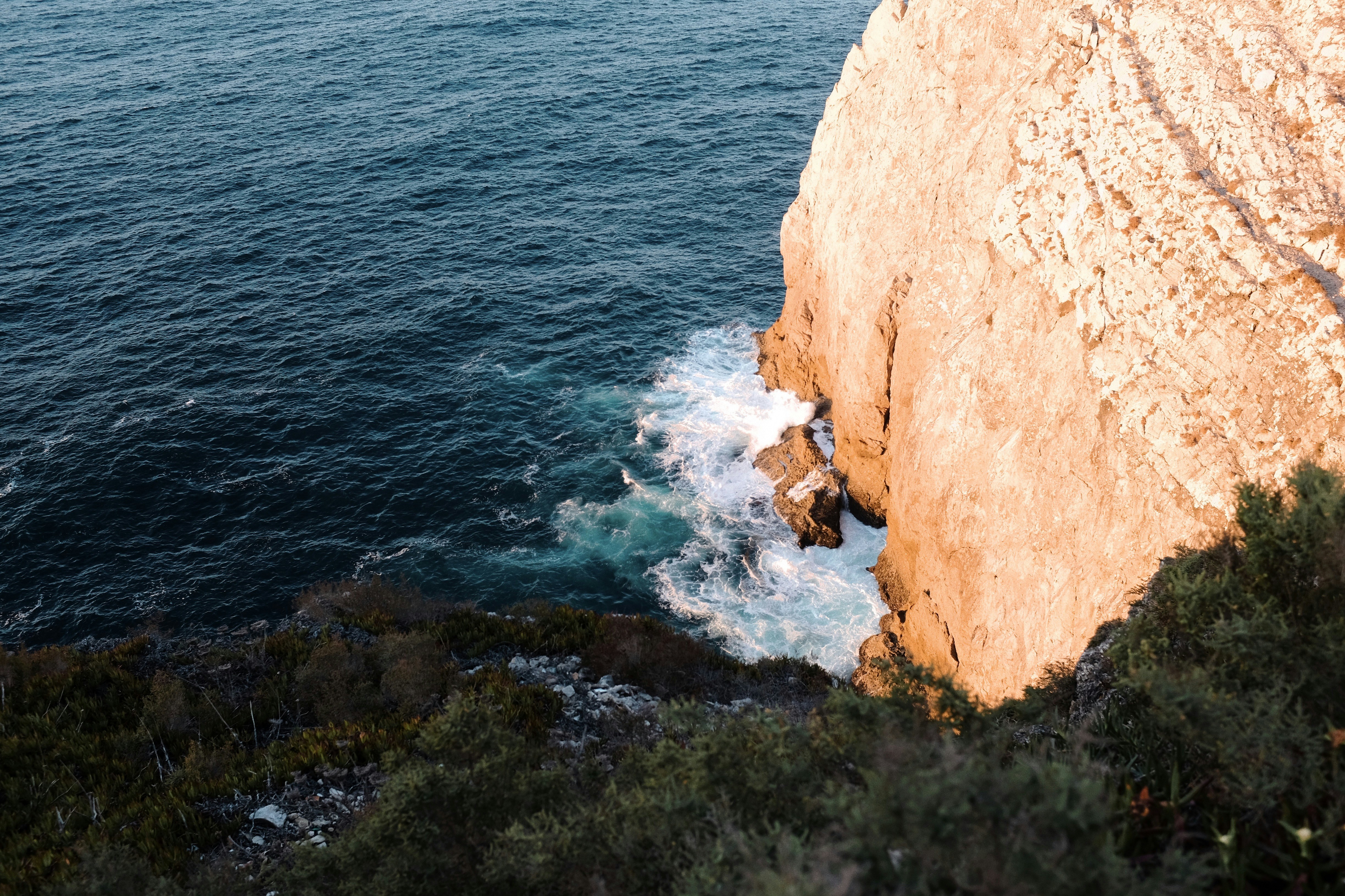 a view of a body of water from a cliff, 