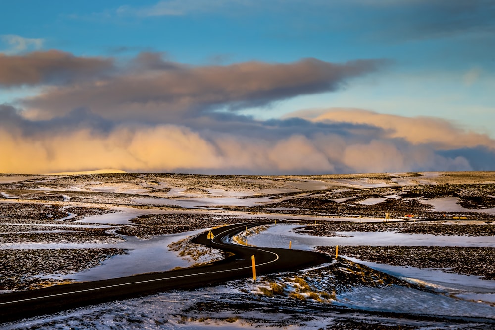 a road in the middle of a snowy field