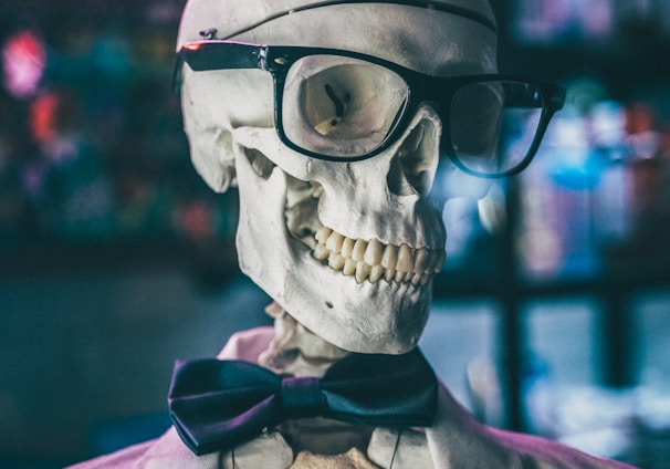 a skeleton wearing glasses and a bow tie