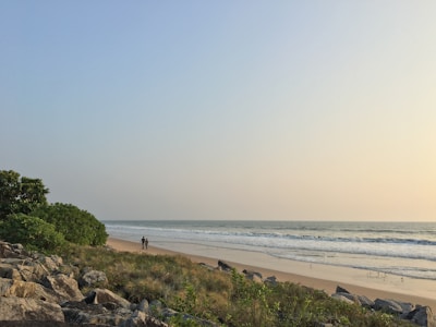 Friendly real estate agent showing land options to a happy couple by the beach.