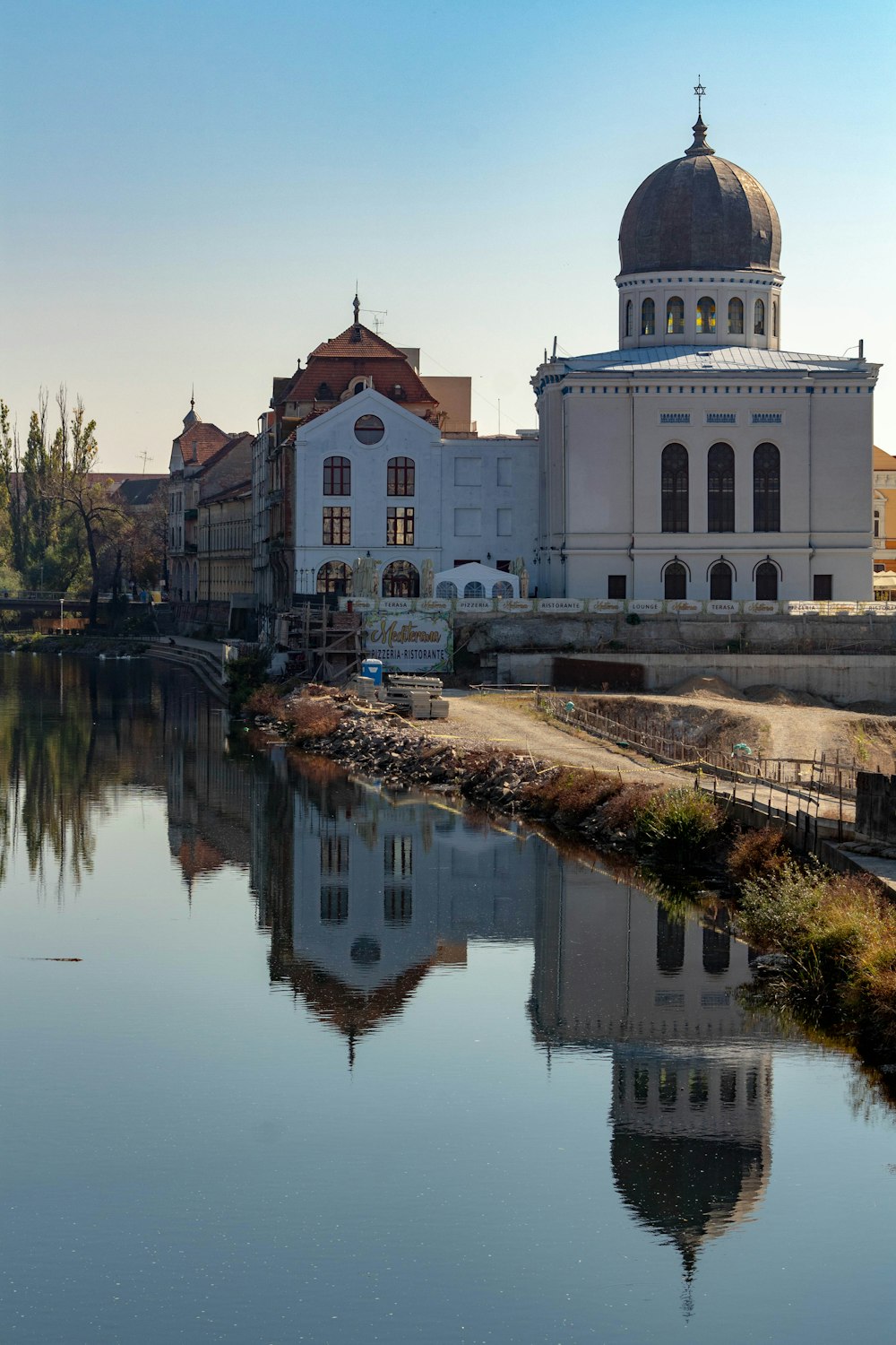 a large white building sitting next to a body of water