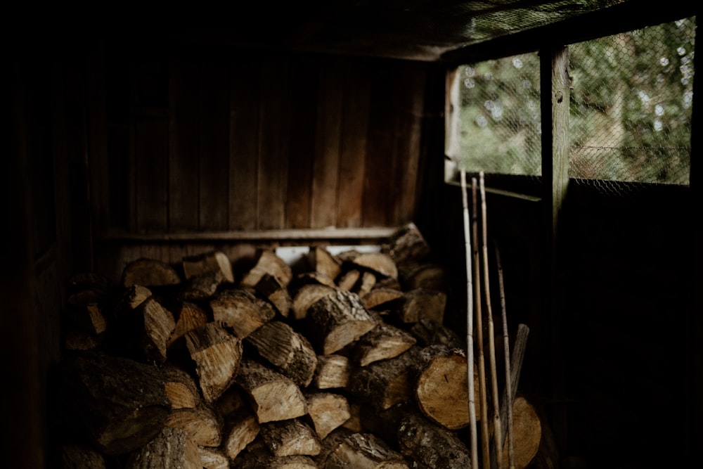 a pile of wood sitting inside of a wooden shed