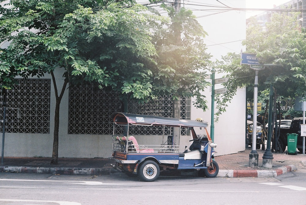 a small blue and red vehicle parked on the side of the road