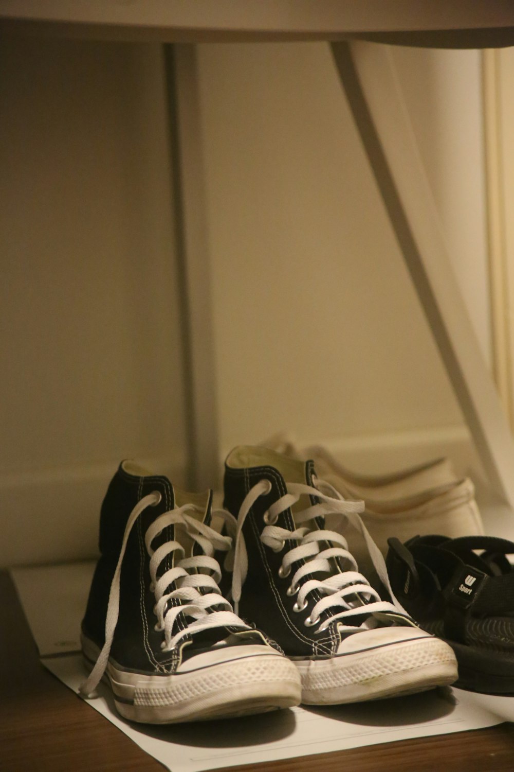 a pair of black and white sneakers sitting on top of a table