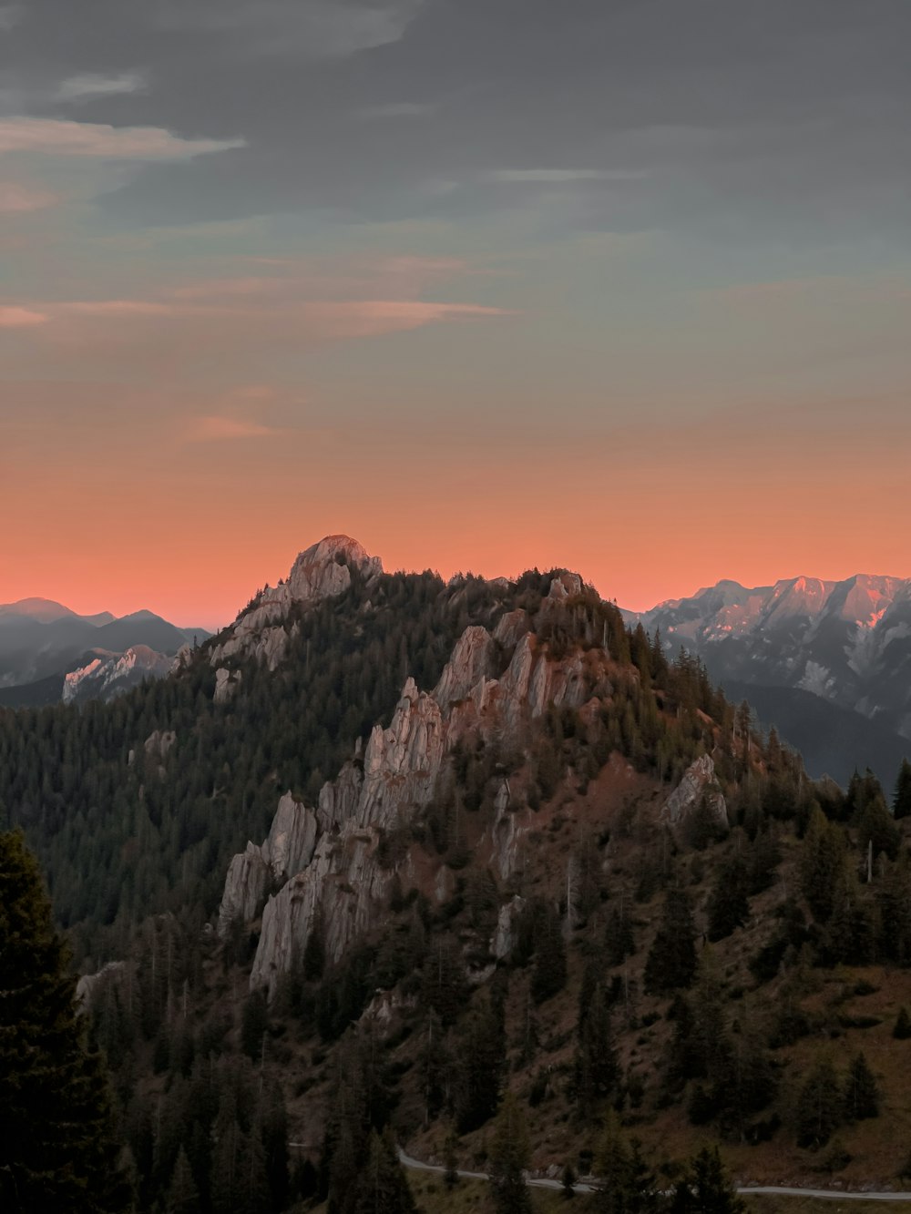 a view of a mountain range with trees and mountains in the background