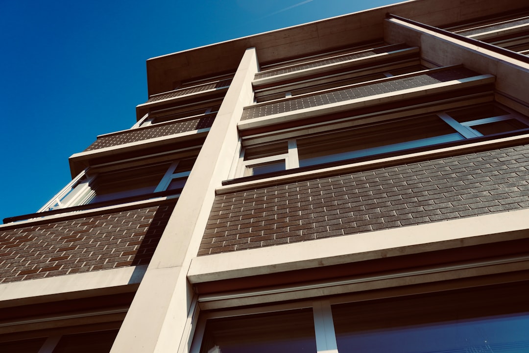 a tall building with windows and a sky background, School Halden Opfikon - Winner of the Architecture Award 2019-2021 Kanton of Zurich by Guignard & Saner Architekten Zürich - photo made by rouichi / switzerland