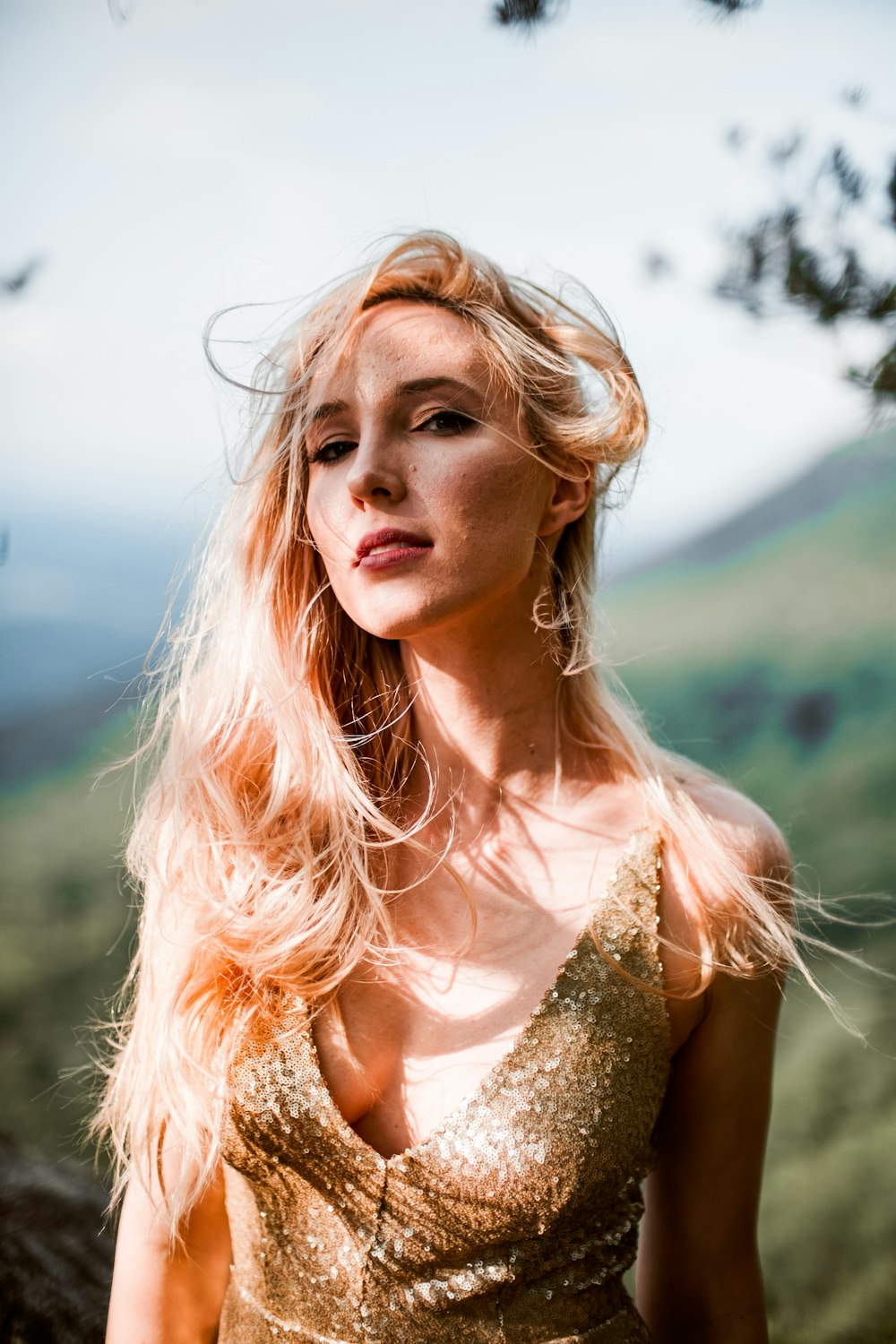 a woman with long blonde hair wearing a gold dress