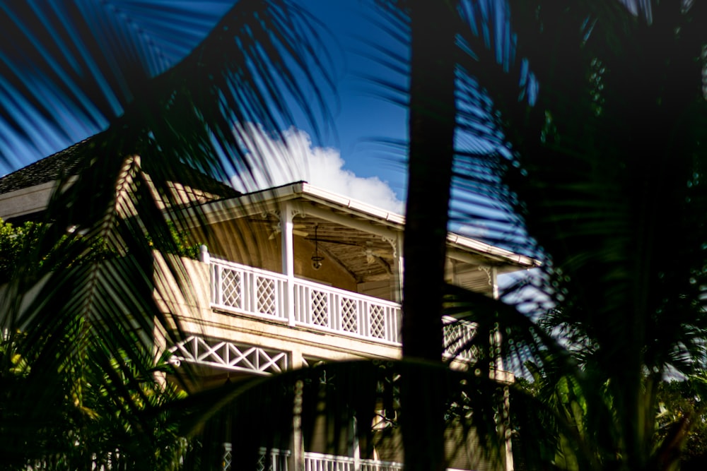 a white house with a balcony and palm trees