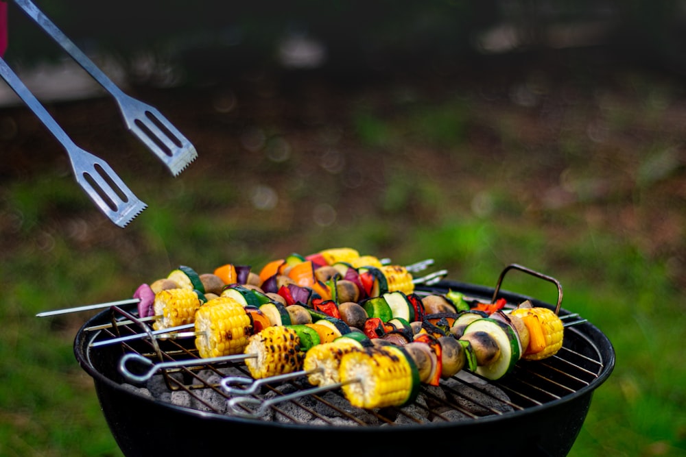 a bbq grill with several skewers of food on it