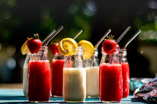 a table topped with three bottles filled with drinks