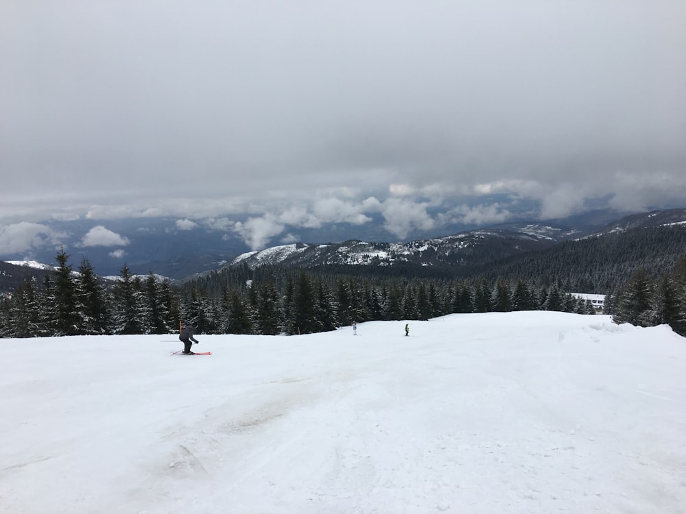 a group of people riding skis on top of a snow covered slope