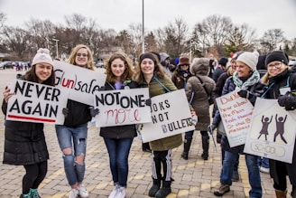 a group of people holding up signs in a parking lot