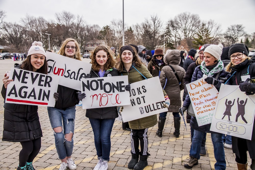 a group of people holding up signs in a parking lot