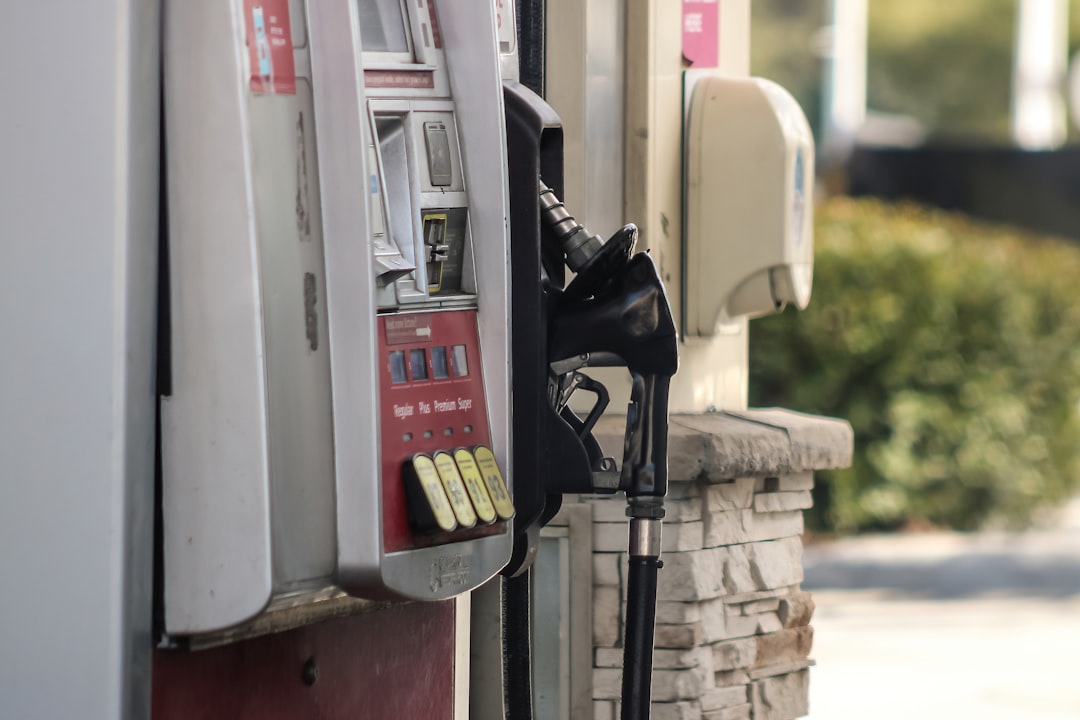 a gas pump next to a brick wall,