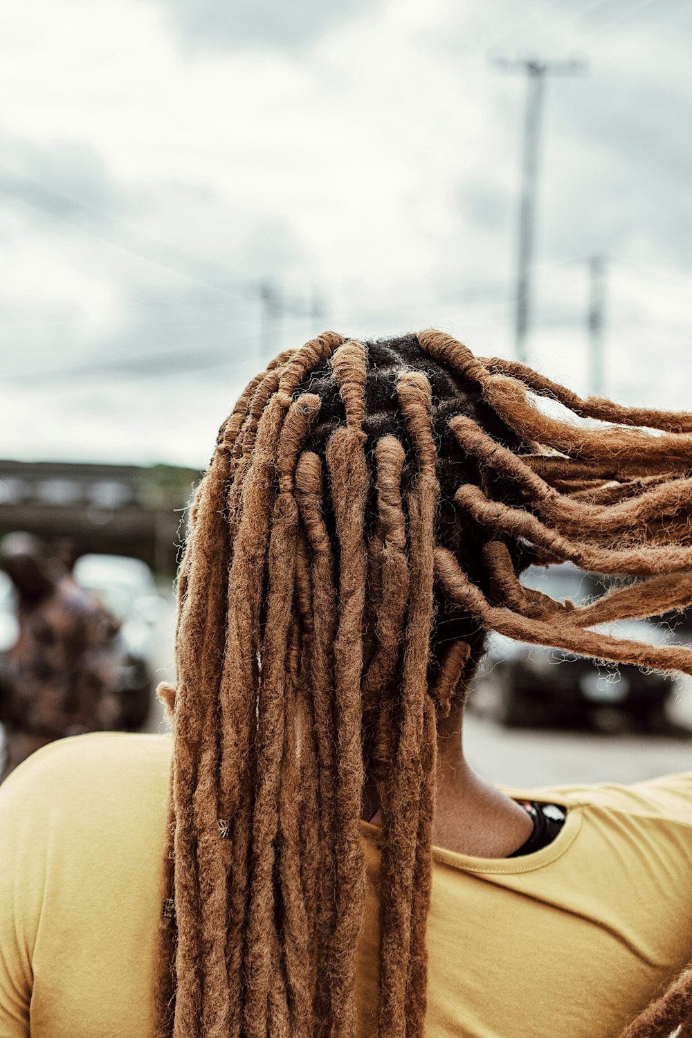 a woman with dreadlocks standing in a parking lot