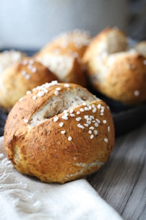 Freshly baked savory bread rolls with herbs on a clean, minimalist background
