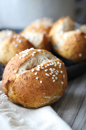 Freshly baked savory bread rolls with herbs on a clean, minimalist background