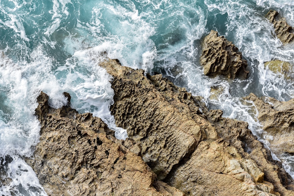 an aerial view of the ocean and rocks