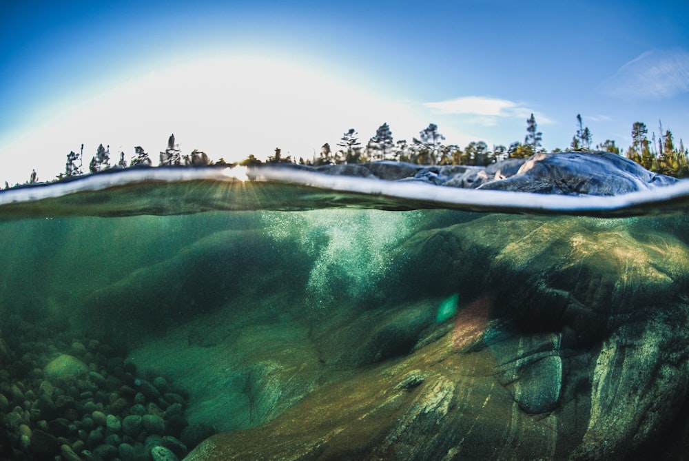 an underwater view of the ocean with a mountain in the background