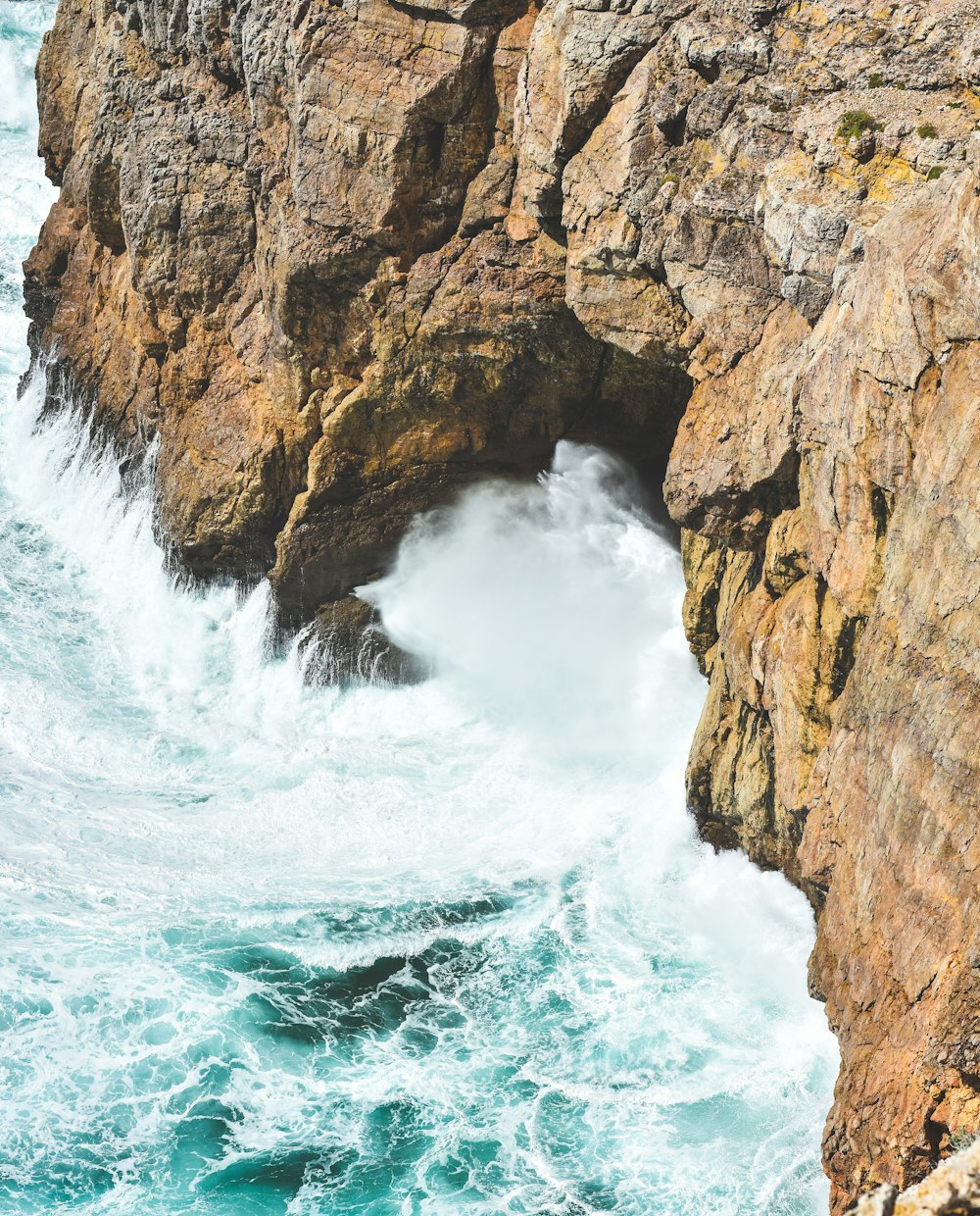 a large body of water next to a rocky cliff