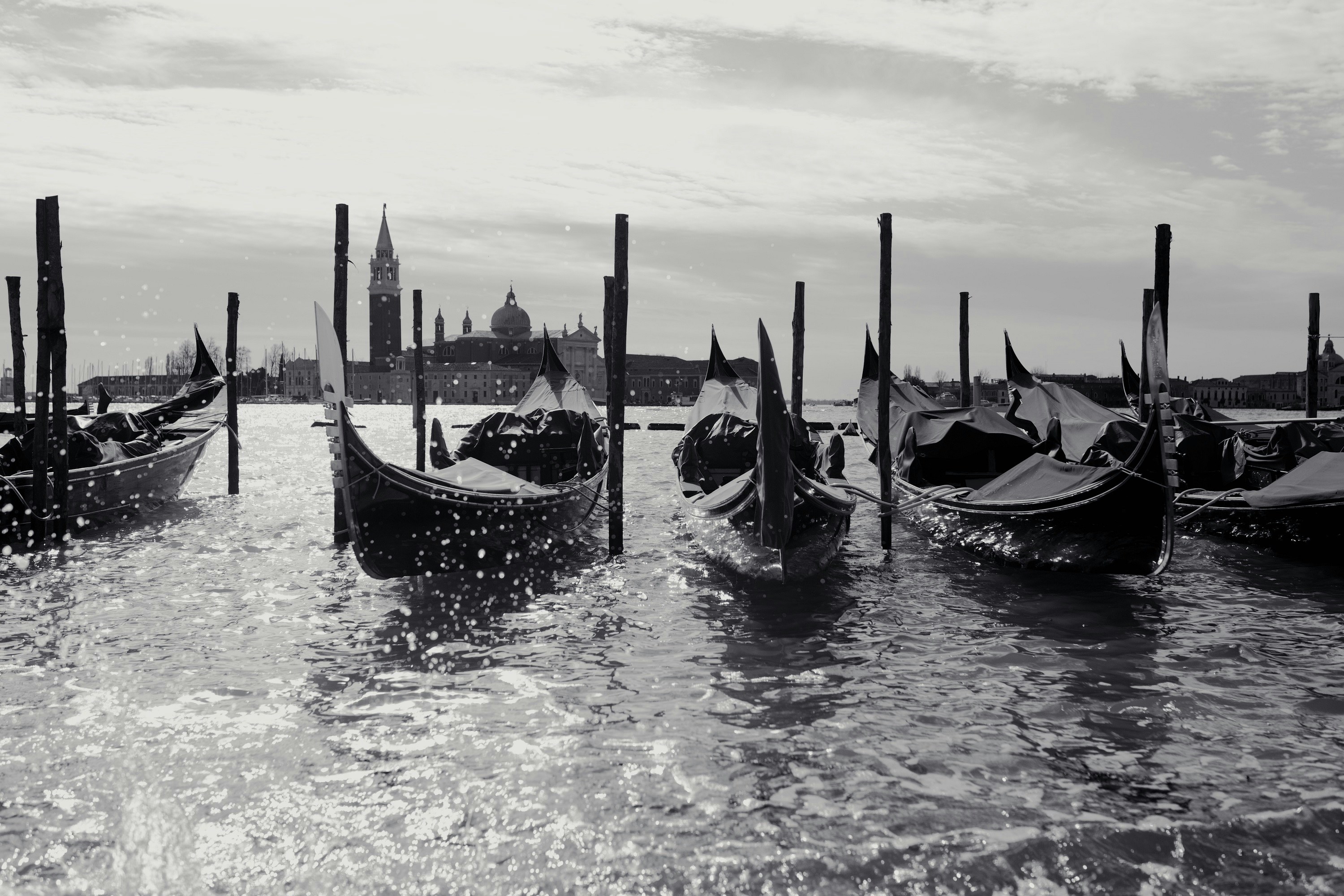 a group of gondolas sitting on top of a body of water