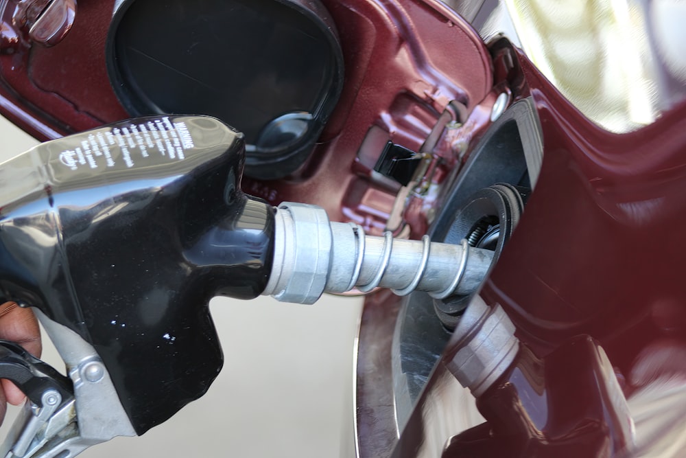 um close up de uma pessoa segurando uma bomba de gasolina