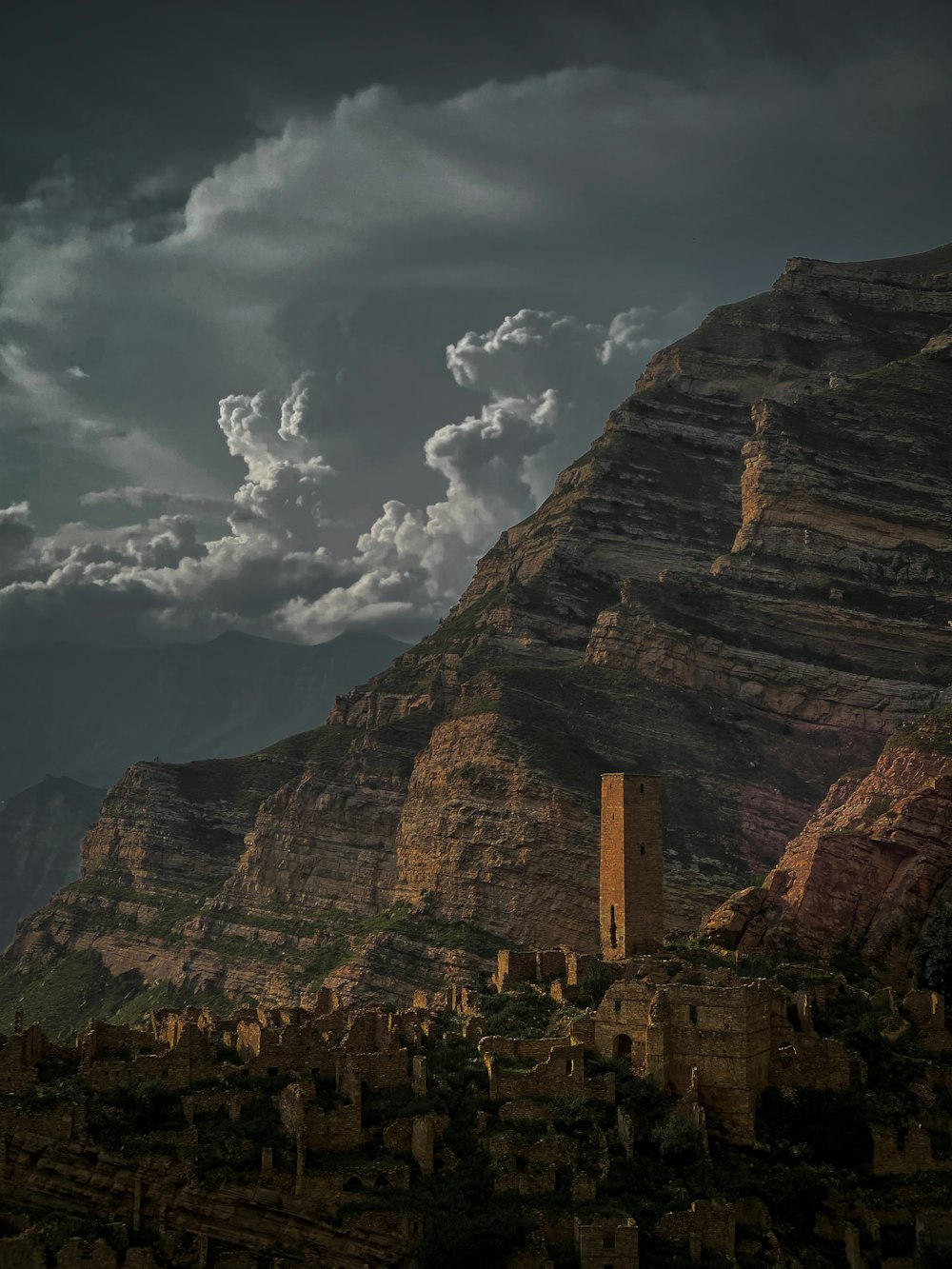 a mountain side with a tower in the middle of it