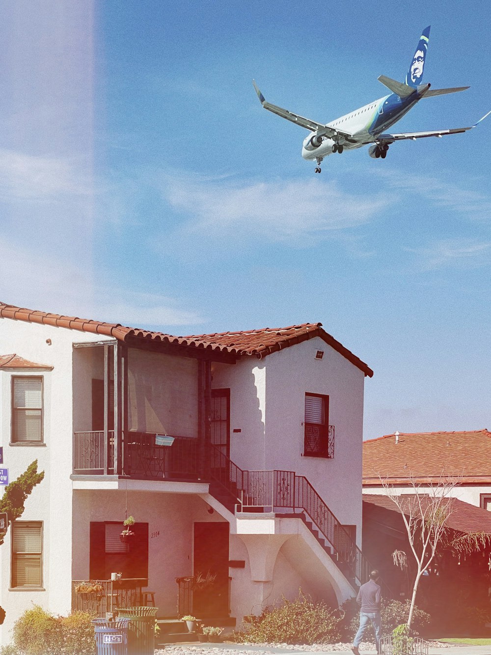 an airplane flying over a building with a balcony and balconies