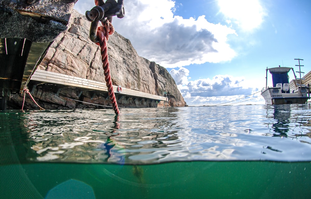 a boat in a body of water next to a cliff