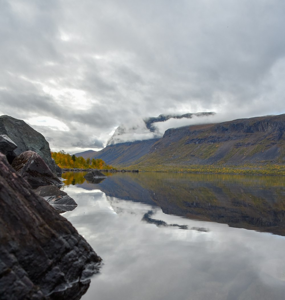 a body of water surrounded by mountains and trees