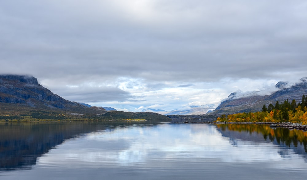 a body of water surrounded by mountains and trees